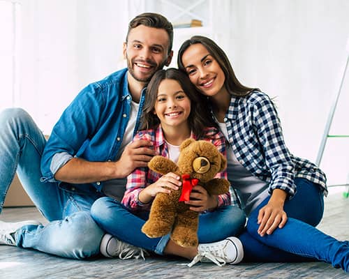 Happy family sitting and hugging after moving into their new house in Rhode Island